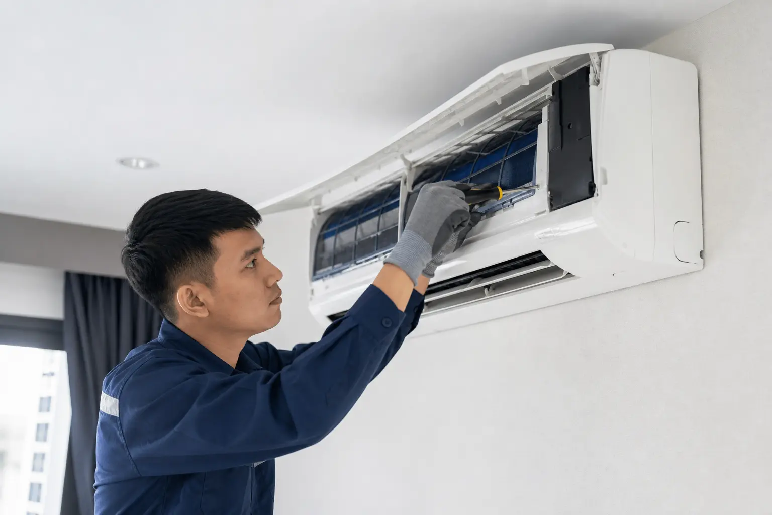 Aircon technician repairing a malfunctioning split-type air conditioner in Dasmariñas, Cavite